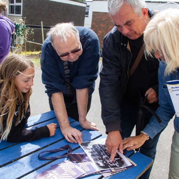 Ex pupils and current pupils looking at photographs